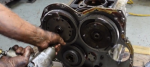 A technician removes the timing gears from a Detroit Diesel 2-cycle engine in order to get to the endplate.